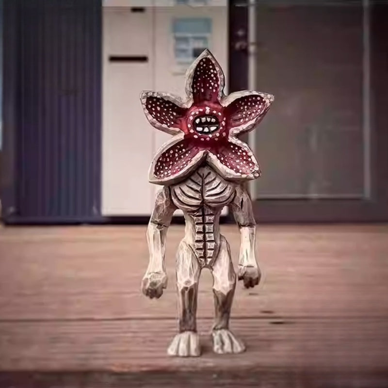 Wooden Demogorgon figure standing on a wooden floor outdoors, capturing natural lighting.
