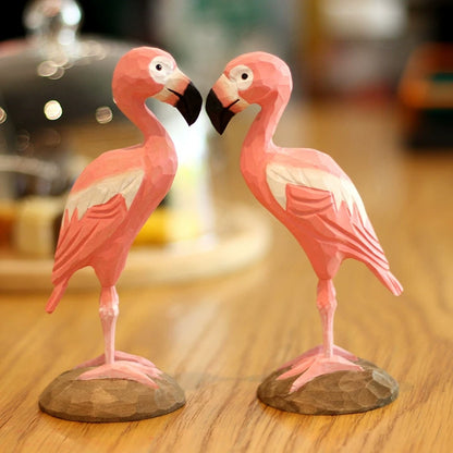 Two flamingo figurines displayed facing each other