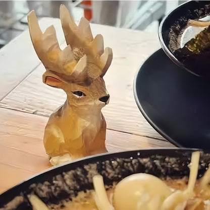 Freestanding wooden reindeer ornament in side view beside a bowl