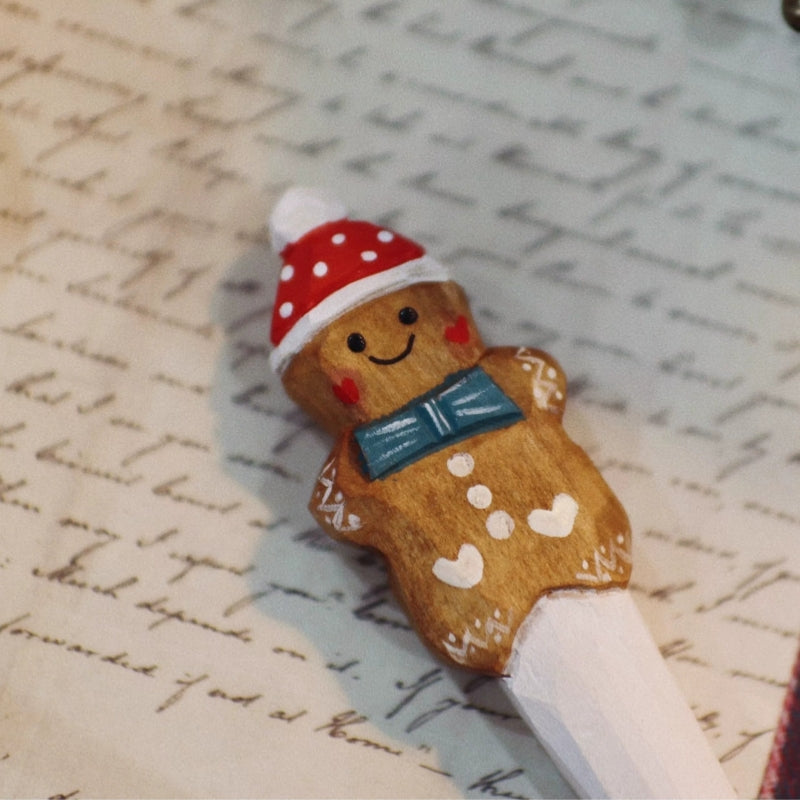 Close-up of the carved gingerbread man pen with a smiling face, teal bow tie, and white icing details