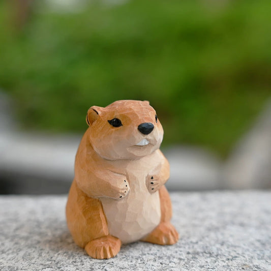 Hand-carved groundhog figurine in alert sentinel pose on granite