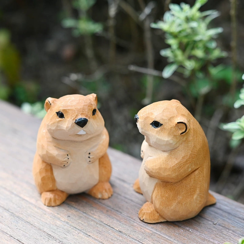 Two groundhog figurines on wooden surface from different angles