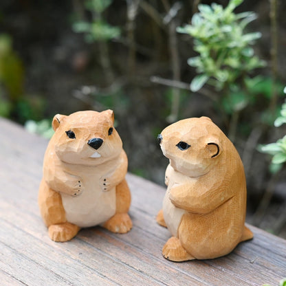 Two groundhog figurines on wooden surface from different angles