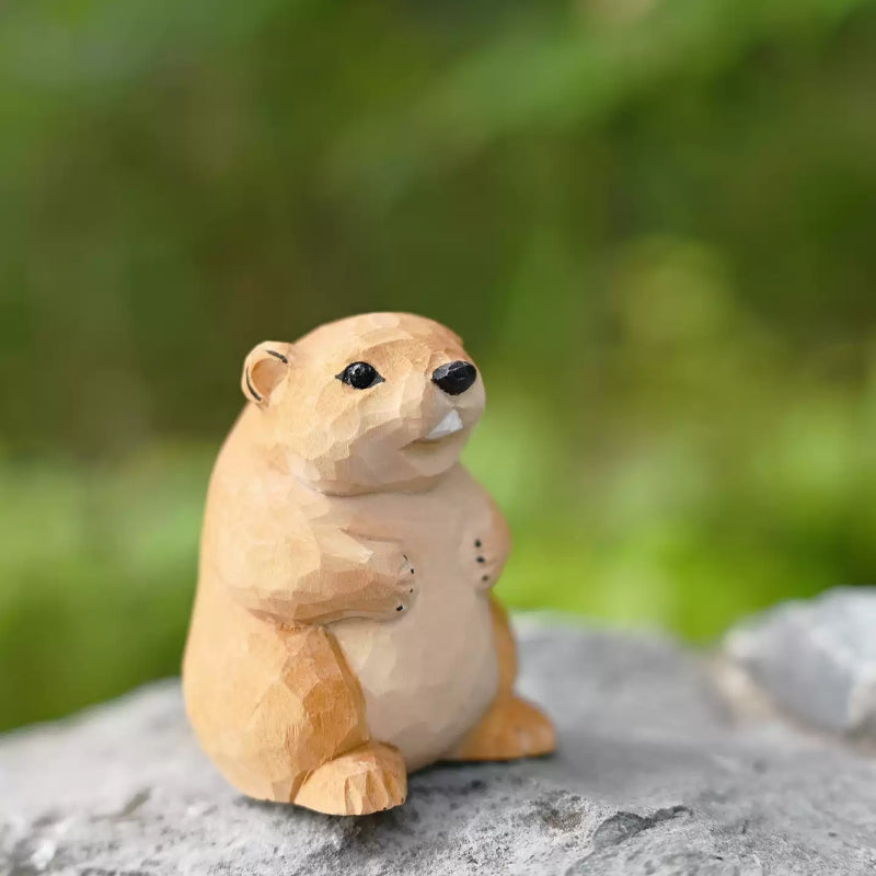 Side view of groundhog wooden figurine on rock