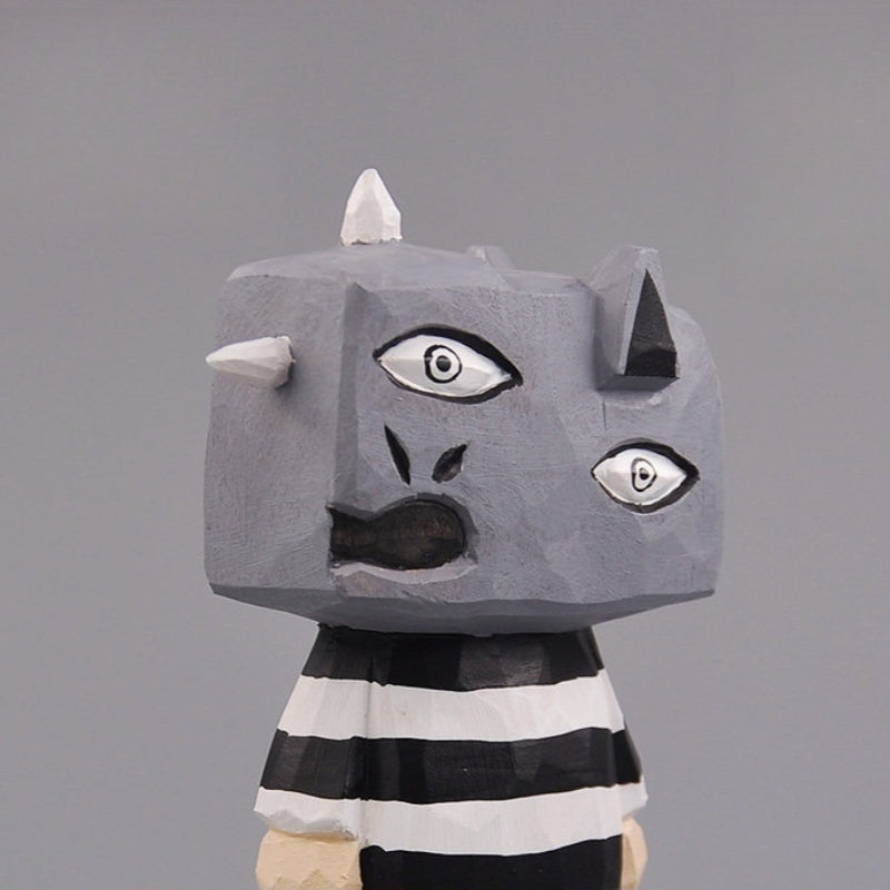 Close-up of wooden monster figure’s head showing Picasso-style expression and horns.