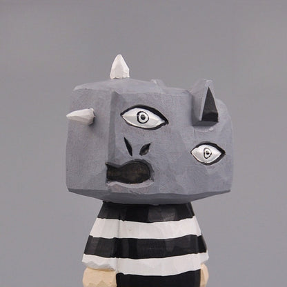 Close-up of wooden monster figure’s head showing Picasso-style expression and horns.