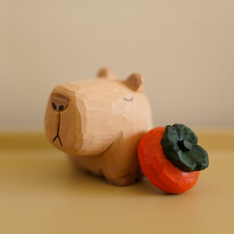 Hand-carved capybara with a separate wooden persimmon beside it