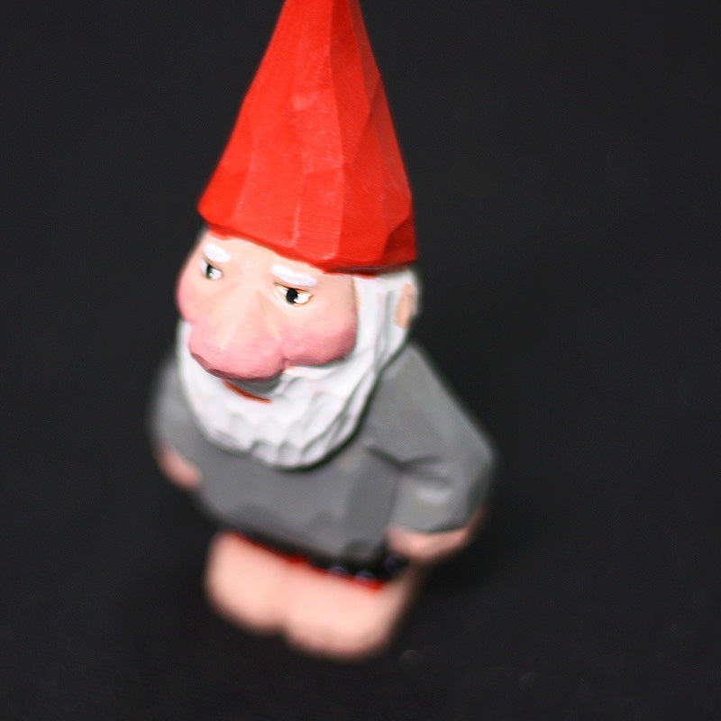 Three-quarter view of the hand-carved gnome with white beard and gray coat