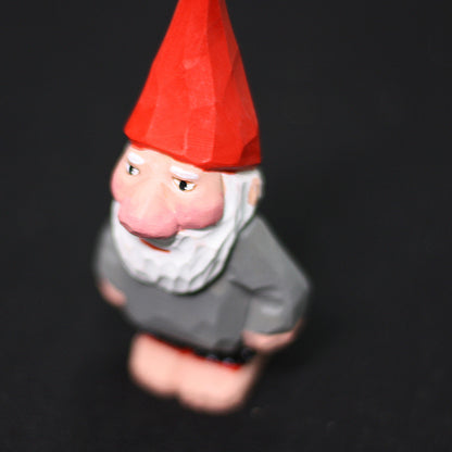 Three-quarter view of the hand-carved gnome with white beard and gray coat
