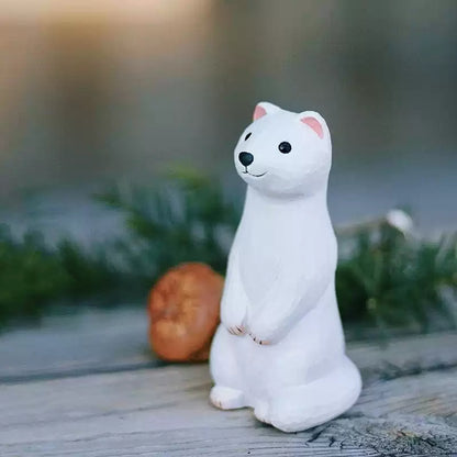 Hand-carved ermine figurine on wood with pine and walnut backdrop