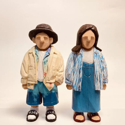 Hand-carved custom figurines of a casually dressed couple in blue and white outfits.