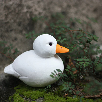 Hand carved wooden duck with a rounded white body and yellow-orange bill
