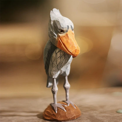 Hand-carved wooden shoebill stork figurine standing on a brown wooden base