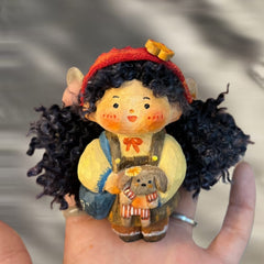 Handcrafted wooden doll keychain of a girl holding a puppy, made from solid wood with soft cotton yarn hair, celebrating warmth and companionship.