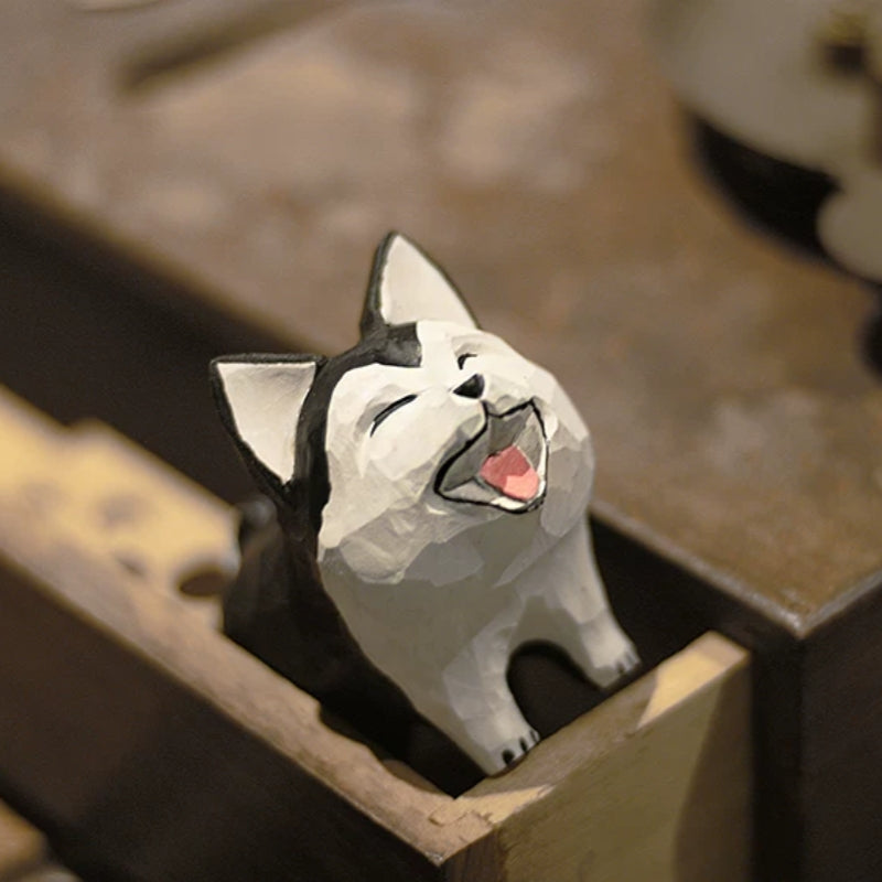 Husky dog figurine peeking from an open wooden drawer with a wide painted smile