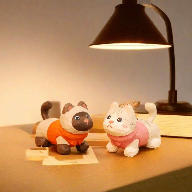 Kitten figurines under warm lamp