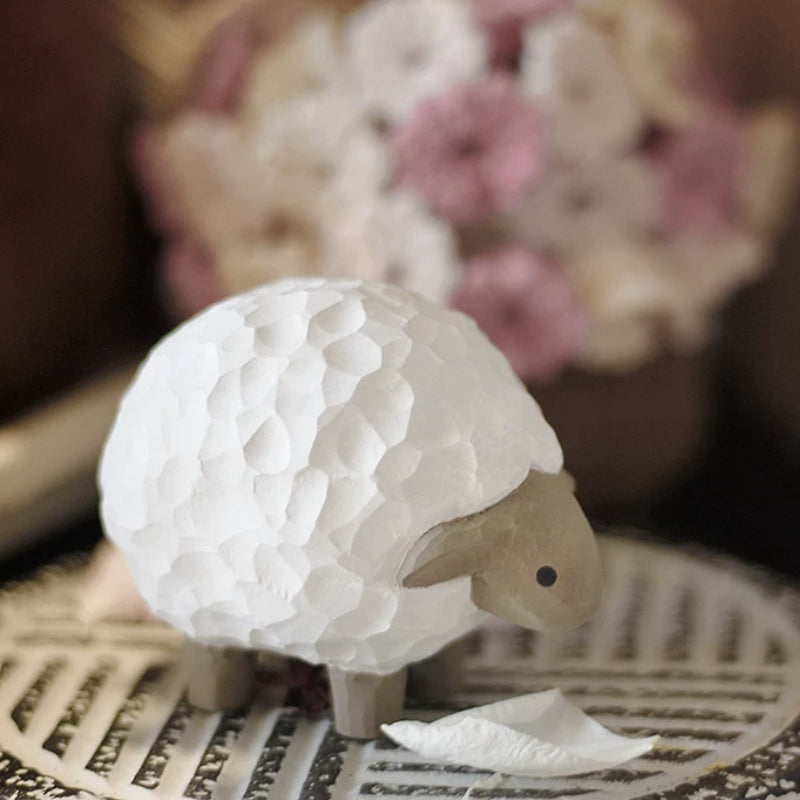 Lamb figurine with floral arrangement backdrop