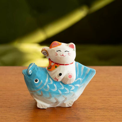 Lucky cat figurine on blue koi close up