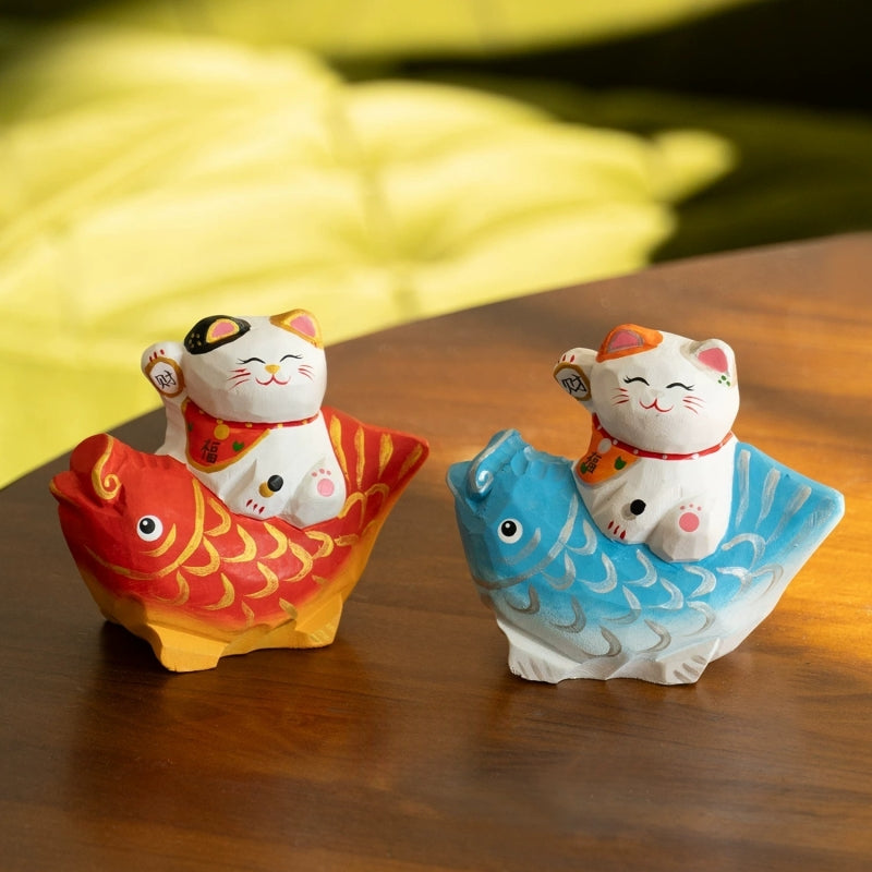 Pair of lucky cat figurines on koi fish
