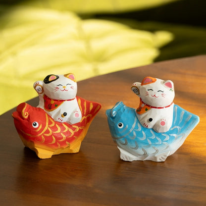Pair of lucky cat figurines on koi fish