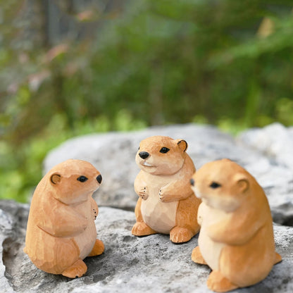 Three marmot figurines together on a rock