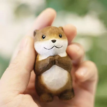 Mini otter figurine held in hand for scale