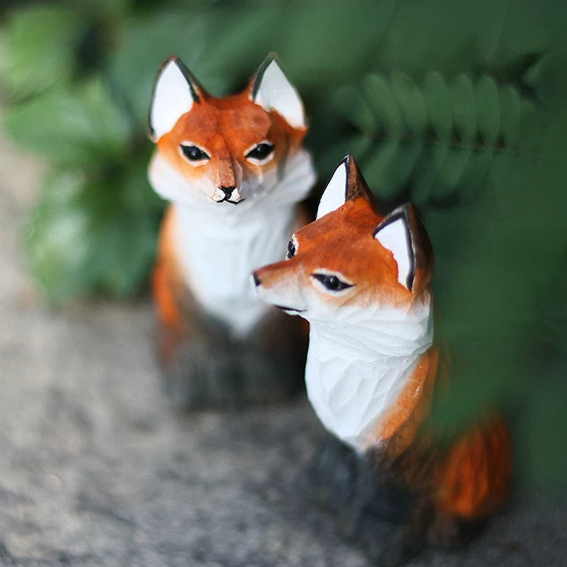 Two miniature red fox figurines close-up