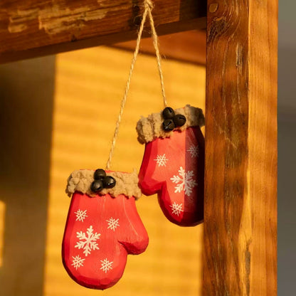 Two red mitten ornaments joined by twine and hanging from a wooden frame