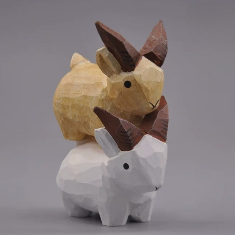 Natural and white goat figurines arranged in a stacked display