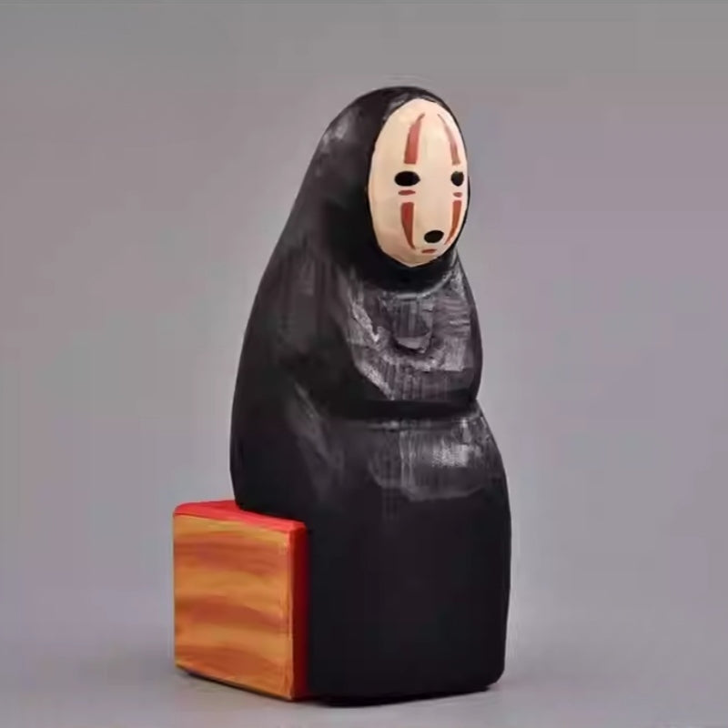 Angled side view of the No Face Figure sculpture showing its minimalist carving.