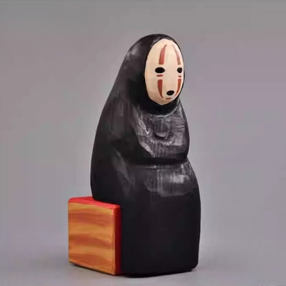 Angled side view of the No Face Figure sculpture showing its minimalist carving.
