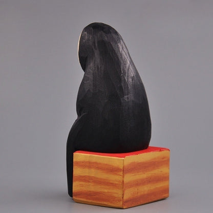 Rear view of the No Face Figure sitting on a painted wooden block seat.