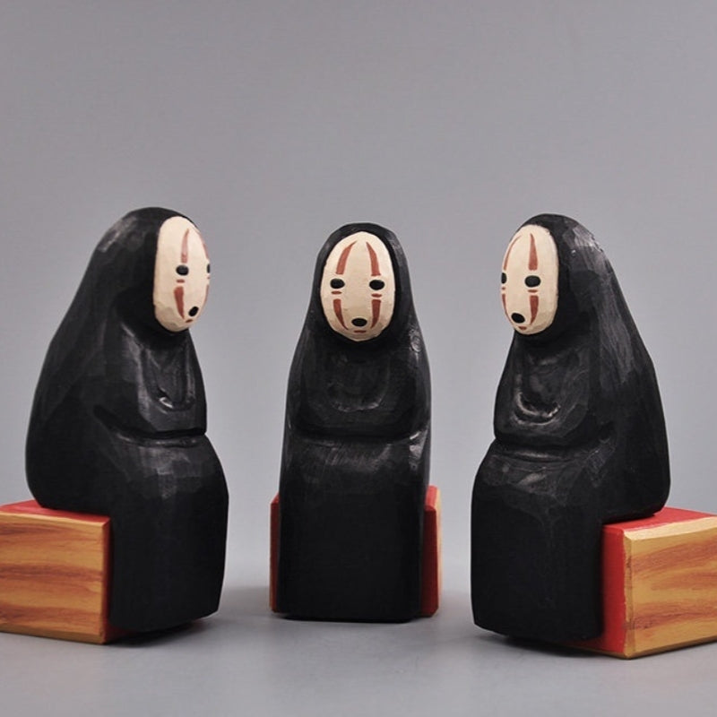 Three No Face Figure sculptures arranged in a triangle formation.