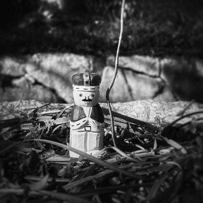 black and white photo of wooden nutcracker figurine outdoors