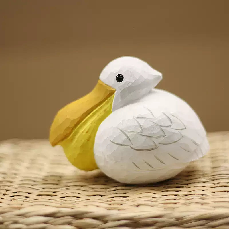 Pelican figurine with oversized yellow bill and white carved body