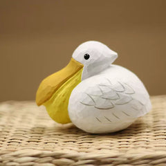 Pelican figurine with oversized yellow bill and white carved body