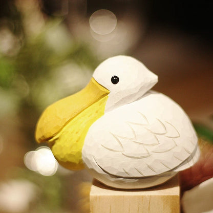 Hand-carved pelican figurine displayed in a warm indoor setting