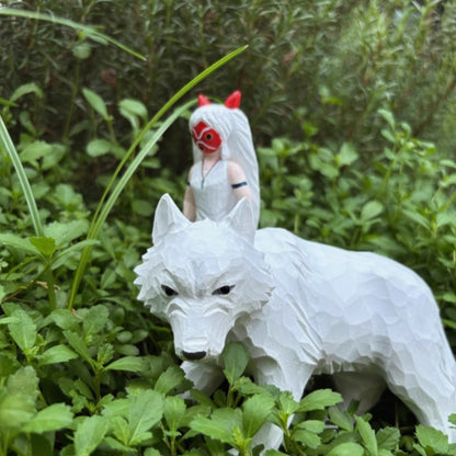 Princess Mononoke wooden figurine displayed outdoors among greenery