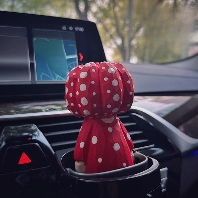 Red polka dot pumpkin head wooden figurine in car cup holder
