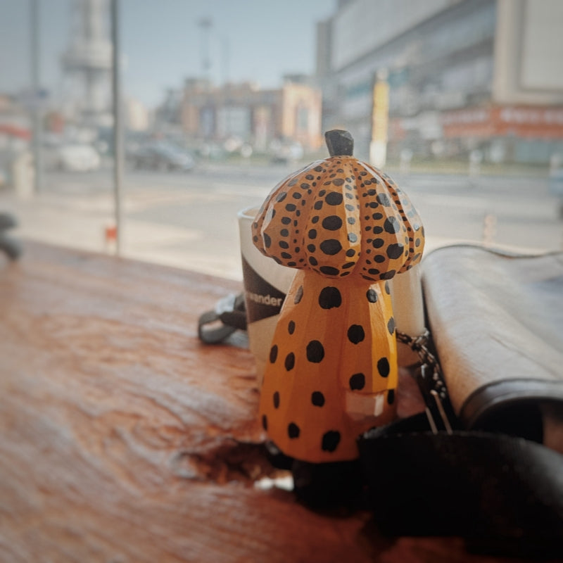 Yellow polka dot pumpkin head wooden figurine on wooden desk