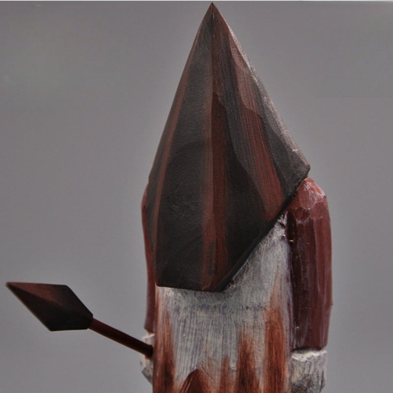 Close-up of Pyramid Head's red and black wooden helmet and weathered white apron