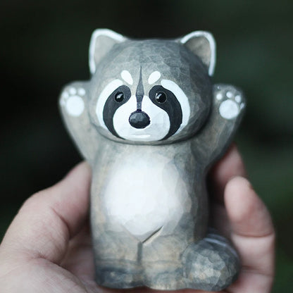 Raccoon wooden figurine held in hand for scale