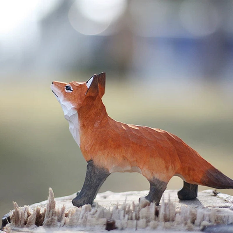 Standing red fox figurine looking up in soft light