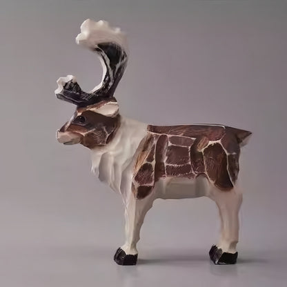 Rustic reindeer figurine with worn paint edges and visible carved planes