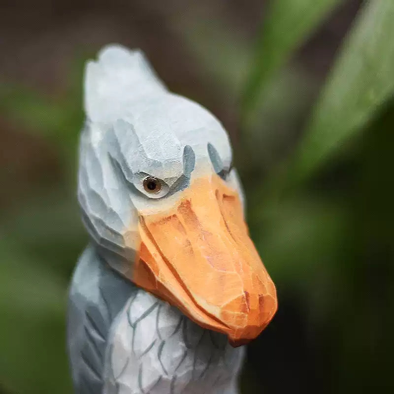 Close view of a wooden Shoebill head with a broad yellow bill and gray plumage