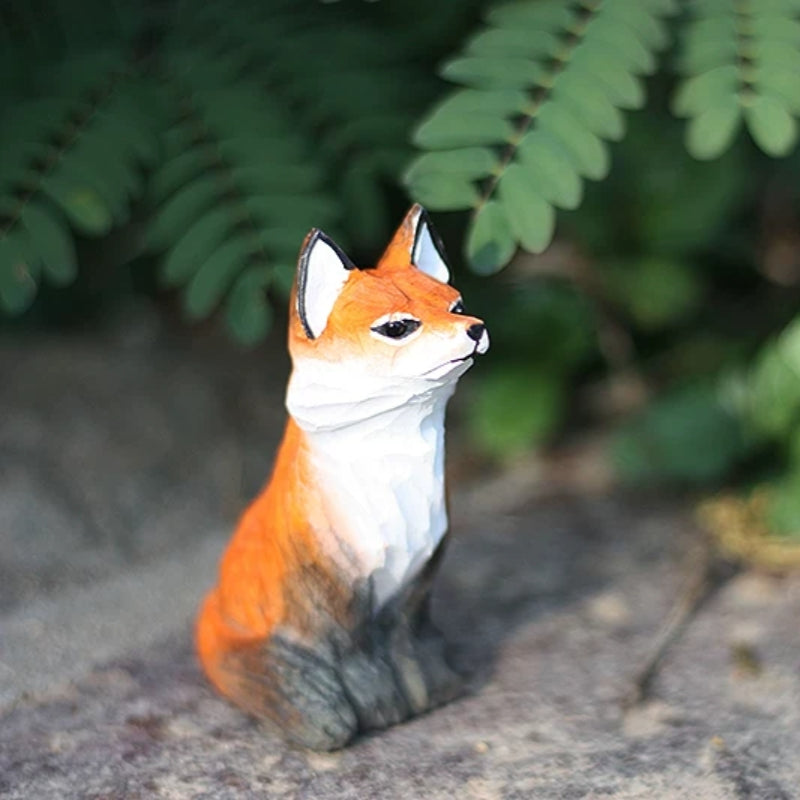 Sitting red fox figurine in fern setting