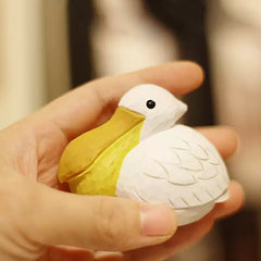 Small pelican figurine held in one hand to show its scale
