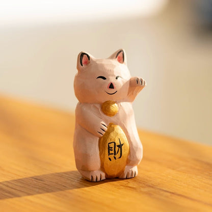 Small pink maneki neko figurine on desk