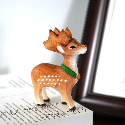 Small Sika deer figurine with warm brown shading, white spots, and a green scarf