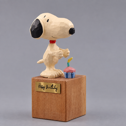 Snoopy figurine standing on the Happy Birthday display block with the detached cupcake beside his feet